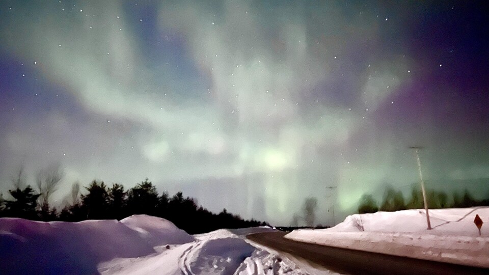 Photo prise au bord d'une route d'un paysage de ciel plein de lueurs vives.