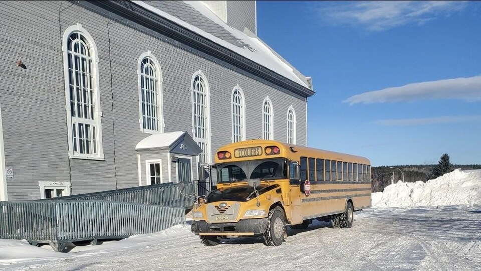 Un autobus à proximité d'une église durant l'hiver.
