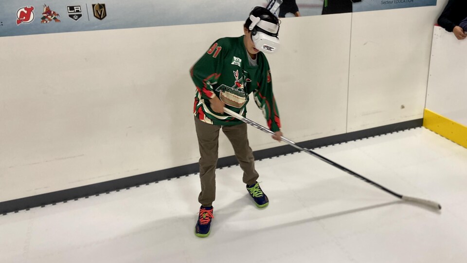 Un jeune de l'équipe de hockey Atanukan fait l'essai d'un casque de réalité virtuelle au nouveau Centre de développement PAC de Uashat. 