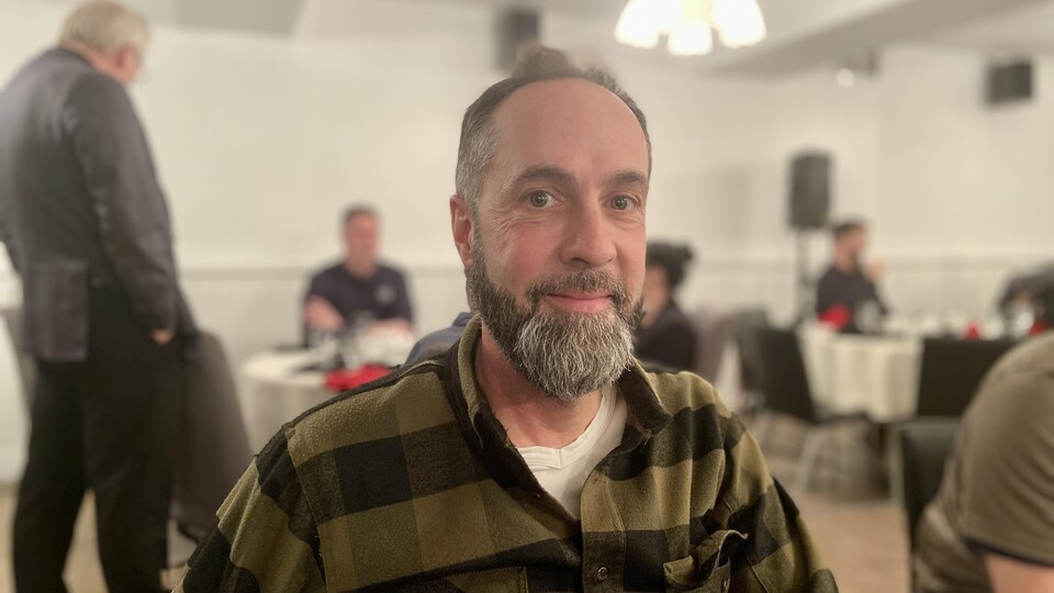 Marc Pelletier porte une chemise et est assis.