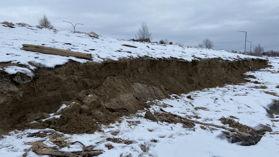 Une plage sous la neige érodée après le passage d'une tempête.