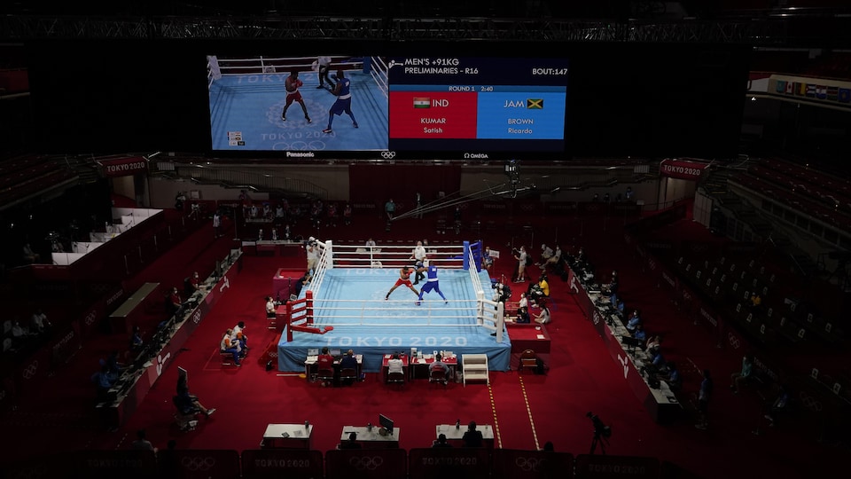 Deux boxeurs s'affrontent dans un ring aux Jeux de Tokyo.