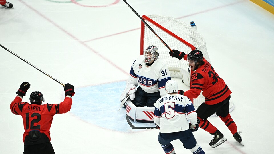 Des joueurs du Canada lèvent les bras.