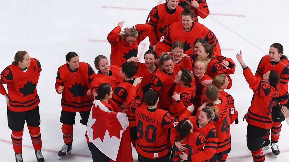 Les Canadiennes célèbrent leur victoire au milieu de la patinoire.