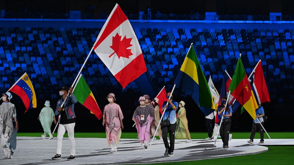 Le Canadien Damian Warner porte le drapeau du Canada. 