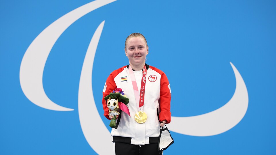Danielle Dorris se tient sur le podium avec sa médaille d'or et son bouquet.