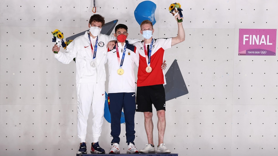 Les trois médaillés sur le podium saluent.
