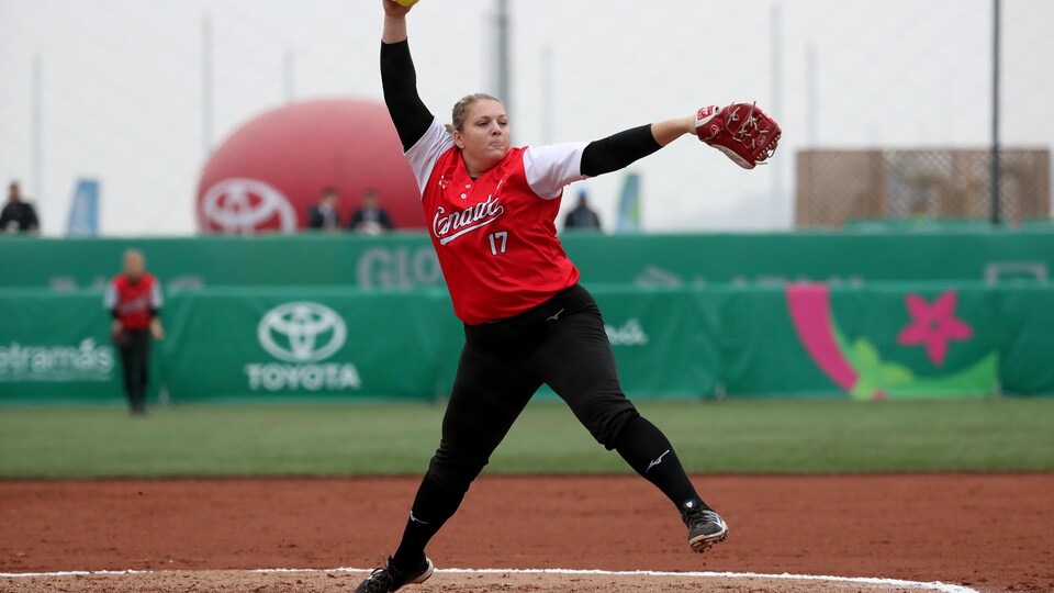 Une joueuse de softball s'élance pour envoyer la balle au marbre.
