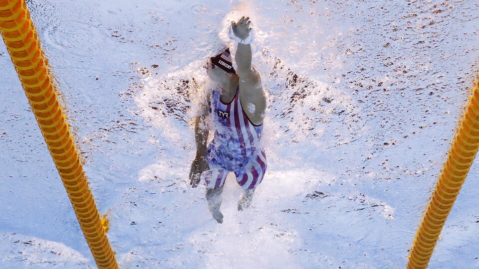 Une jeune femme prend sa respiration pendant une compétition de natation.