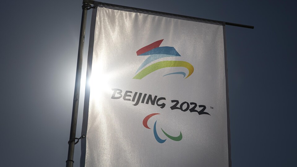 Un drapeau, avec le logo des Jeux paralympiques de Pékin, est éclairé par le soleil.