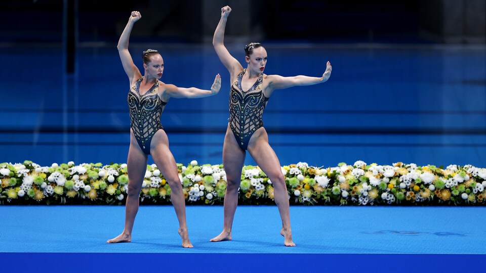 Les deux femmes font une chorégraphie hors de l'eau avant de sauter dans la piscine.