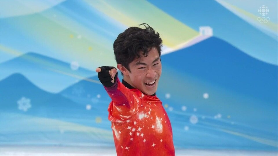 Nathan Chen sourit en pointant le doigt vers la caméra.