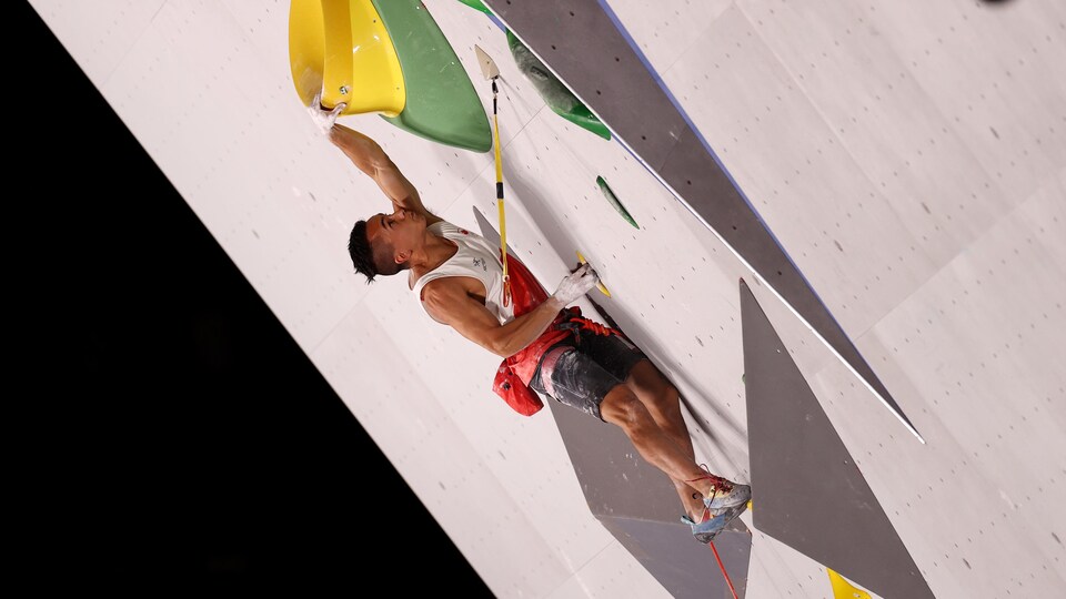 Le grimpeur monte un mur d'escalade aux Jeux olympiques de Tokyo.