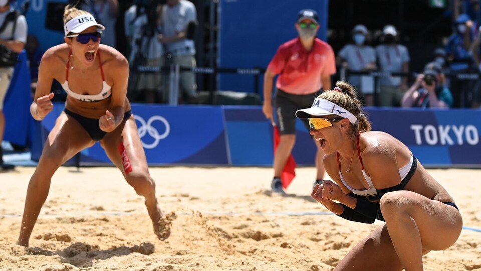 Deux joueuses de volleyball de plage crient et célèbrent leur victoire sur le terrain.