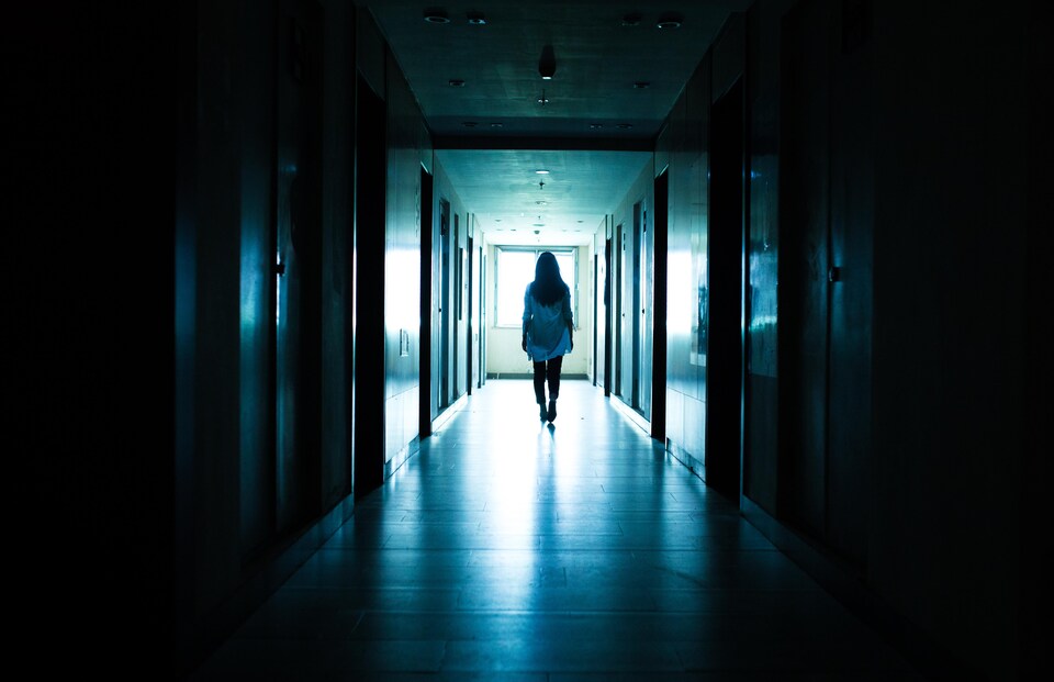 Une femme marche dans un couloir d'écolesombre