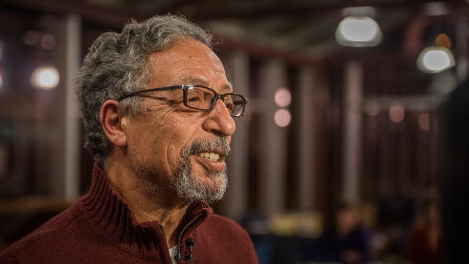 M. Arfa est photographié de trois quarts, souriant, à la bibliothèque.