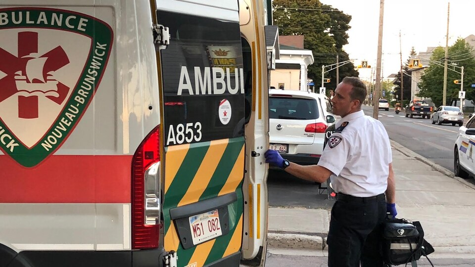 Un paramédical ferme les portes d'une ambulance.