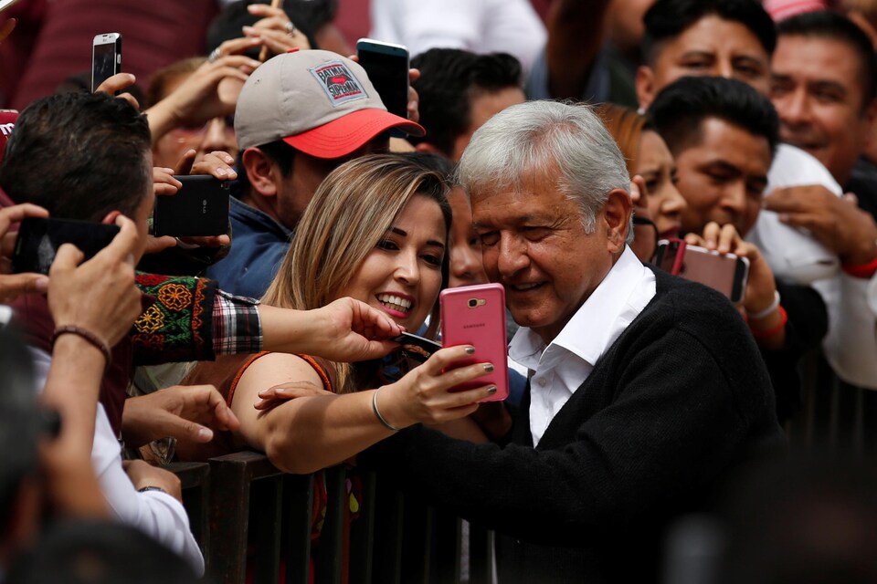 Le leader de l'opposition mexicaine, Andrés Manuel Lopez Obrador, prend un égoportrait avec une supportrice lors de son rassemblement politique de dimanche, à Mexico