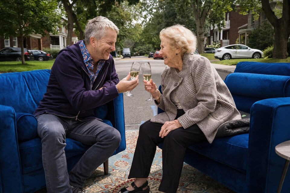 André Robitaille et Antonine Maillet, verre de champagne à la main, portent un toast.