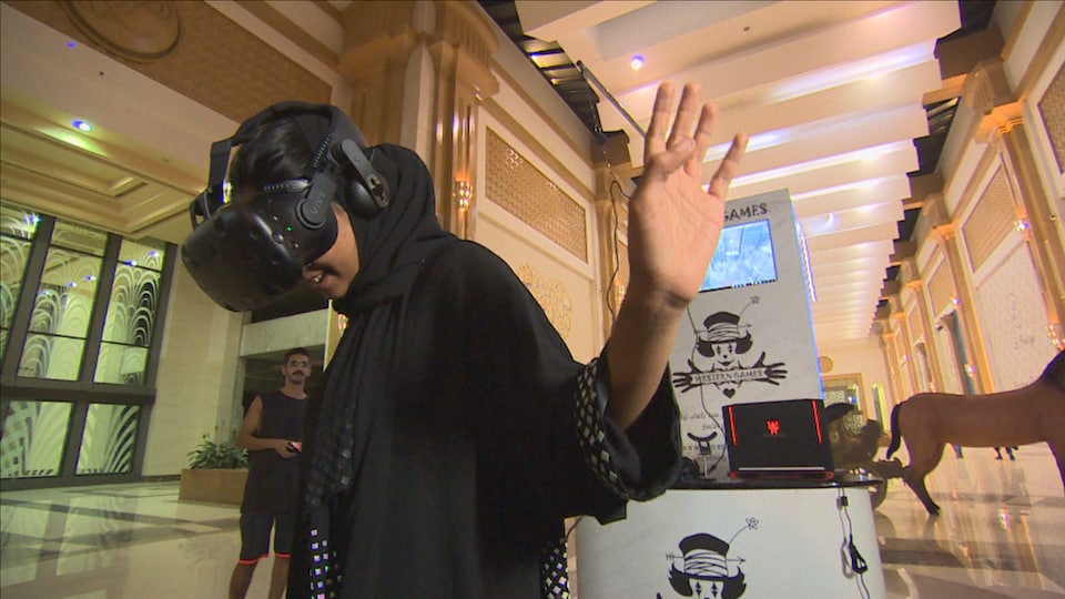Une jeune femme saoudienne fait l'essai d'un casque de réalité virtuelle.