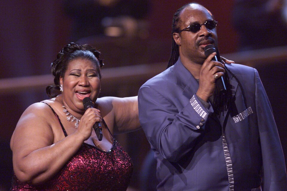 Aretha Franklin tient Stevie Wonder par l'épaule alors que les deux artistes chantent lors d'un concert en 2001 à New York.