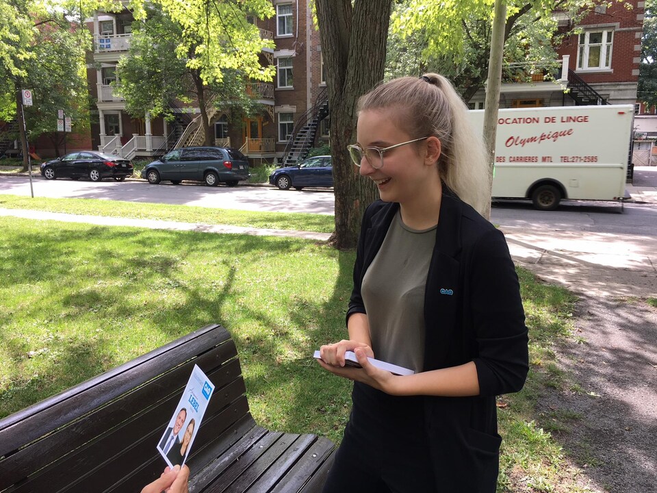 La jeune fille distribue des tracts.