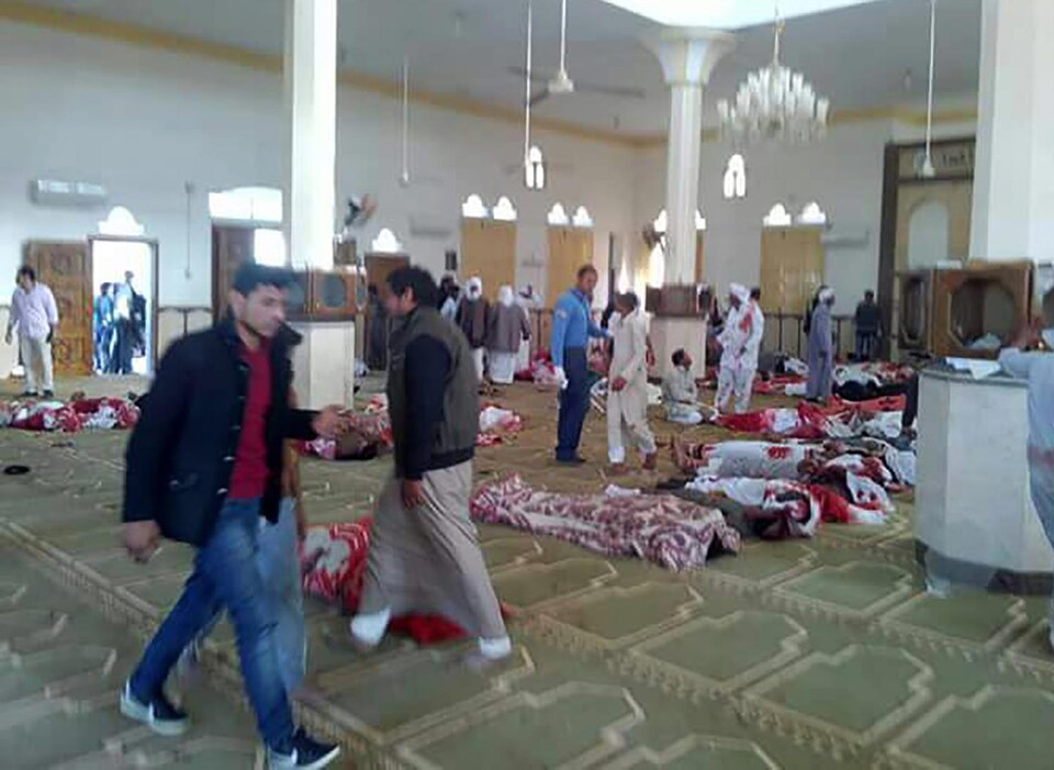 Des corps protégés par des couvertures sont alignés sur le sol de la mosquée.