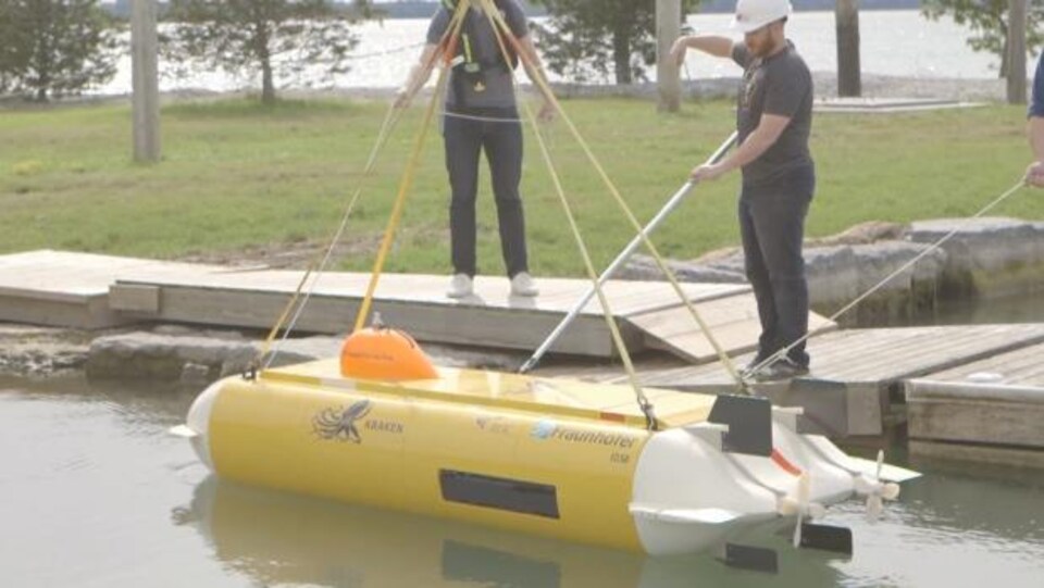 des chercheurs avant un petit bateau pour retrouver l'avion Avro Arrow dans le fond du lac Ontario