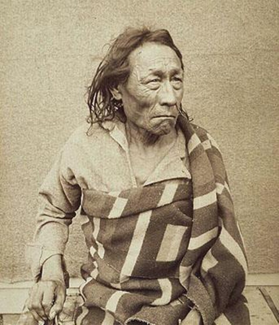 Un autochtone âgé prend la pose dans un photographie d'époque.