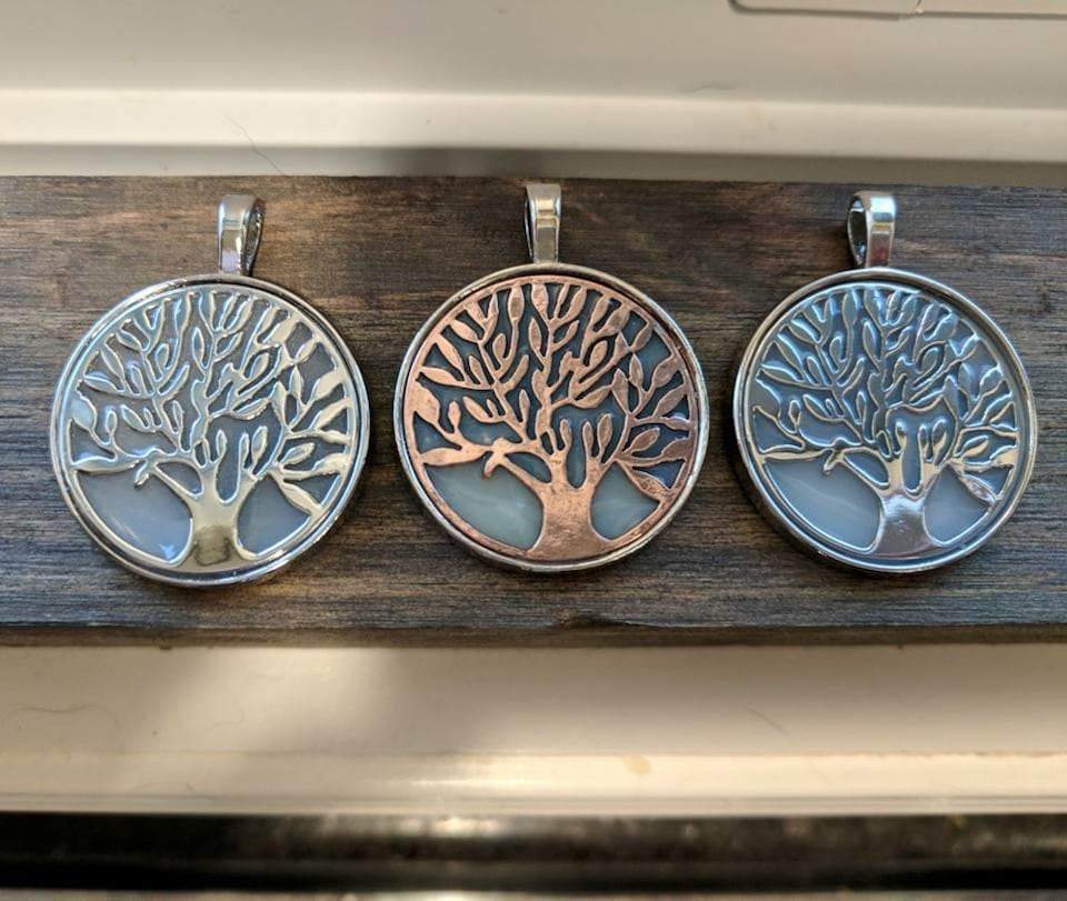 Trois pendentifs illustrés d'un arbre.