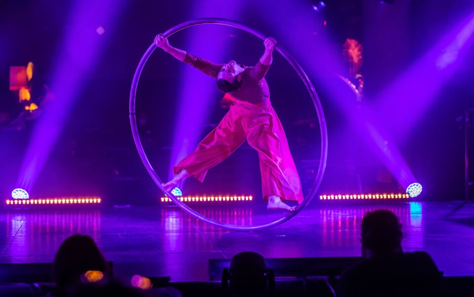 Un acrobate en train de présenter un numéro de roue sur une scène.