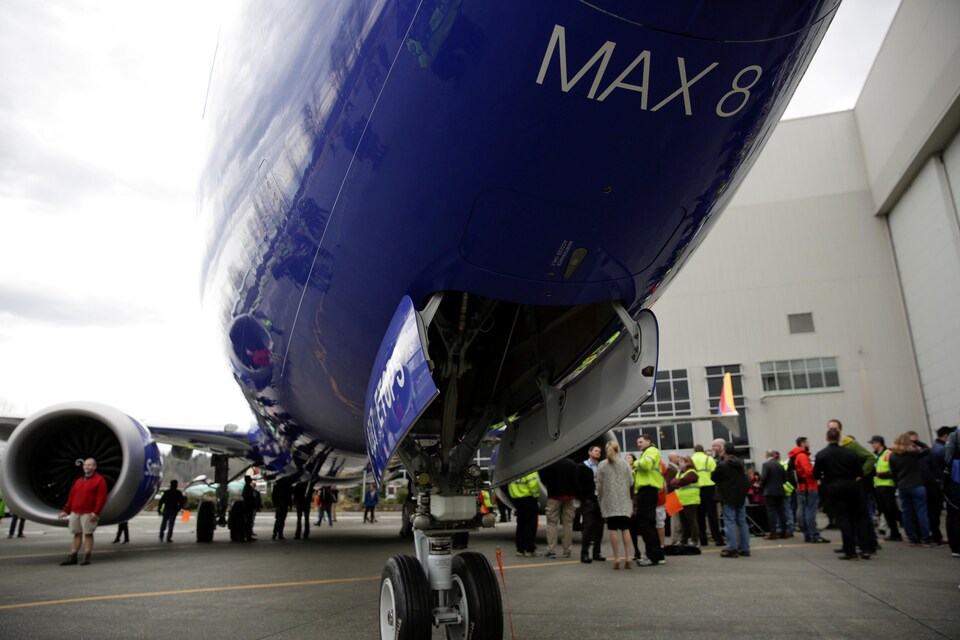 Des employés de Boeing devant un avion.