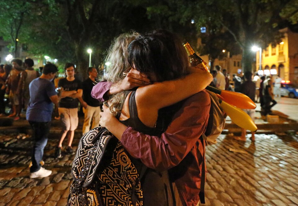 Deux femmes se serrent dans les bras dans un lieu public