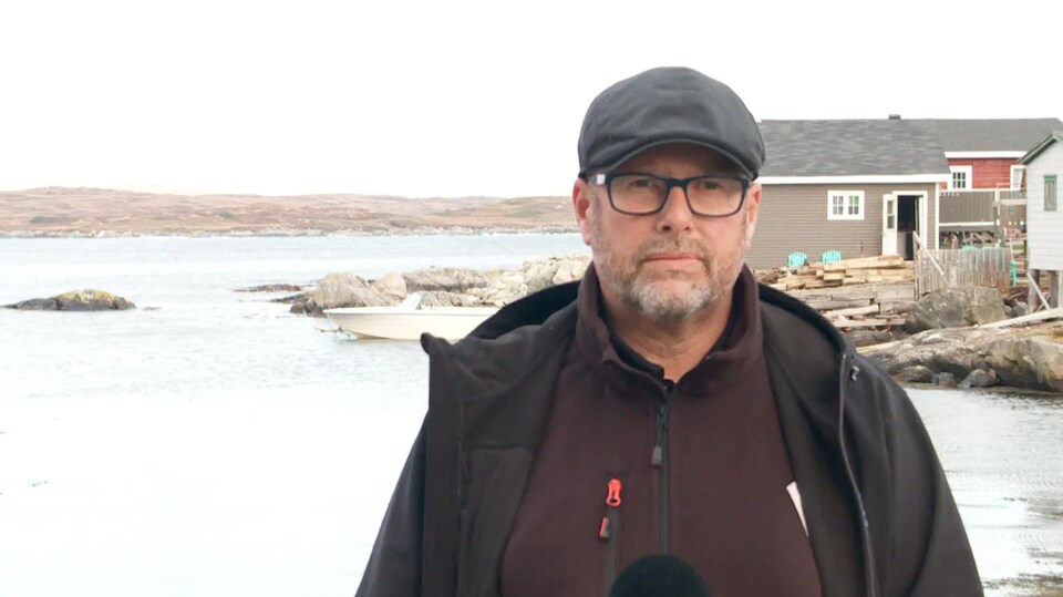 Brian Button interviewé devant la mer.