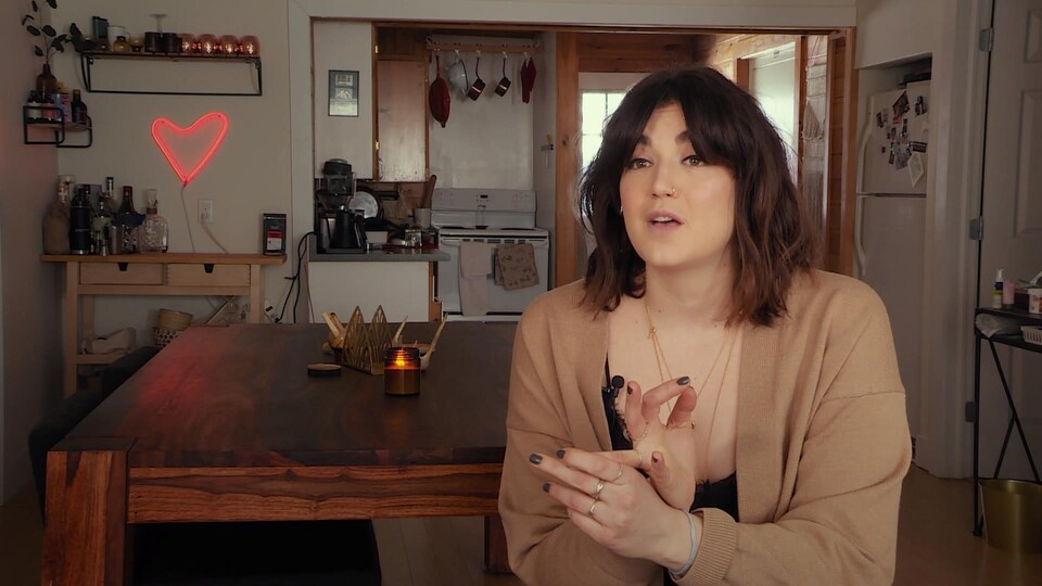 Une femme parle devant la caméra.