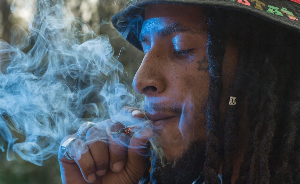 Un homme fume du cannabis