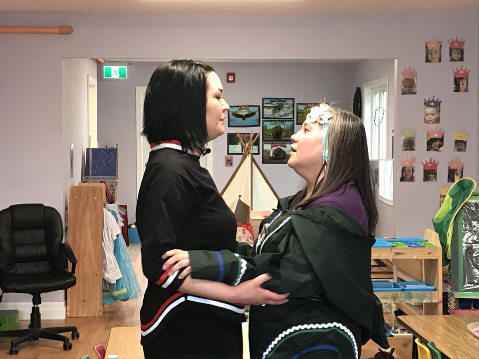 Deux femmes se tiennent debout, face à face, dans une garderie. 