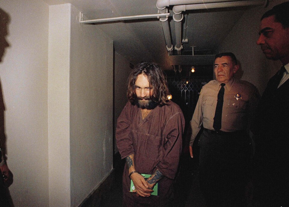 Charles Manson est escorté par un agent lors de son procès pour avoir ordonné sept meurtres, en 1969. 