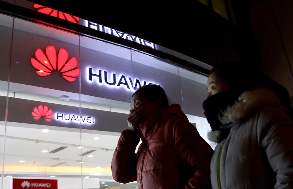 Deux femmes passent devant un magasin du géant chinois Huawei.