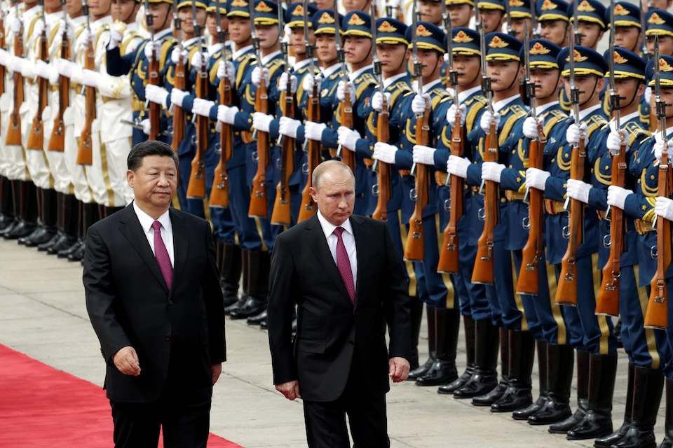 Le président russe (droite) Vladimir Poutine passe en revue l'armée chinoise en compagnie de son homologue Xi Jinping, à Pékin. 