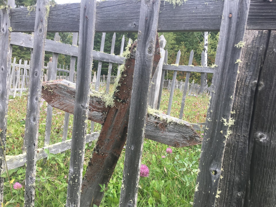 Une croix de bois entourée d'une clôture de bois.