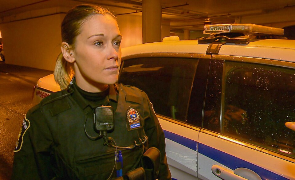 La constable Johanie Ouellet du Service de police de la Ville de Québec lors d'une entrevue près d'une voiture de patrouille.