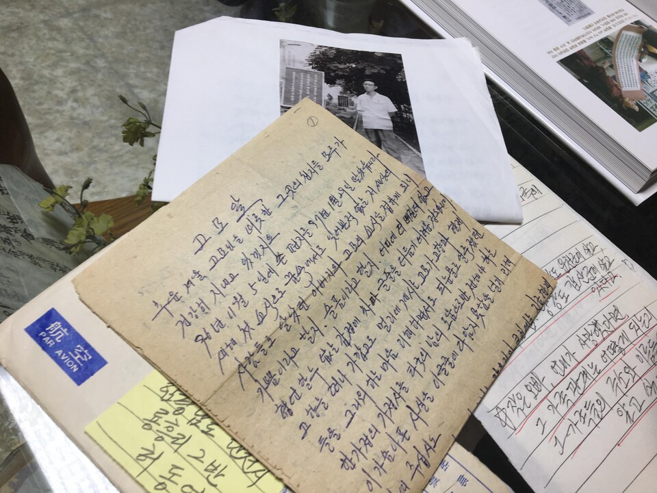 Une lettre manuscrite en coréen et une photo.