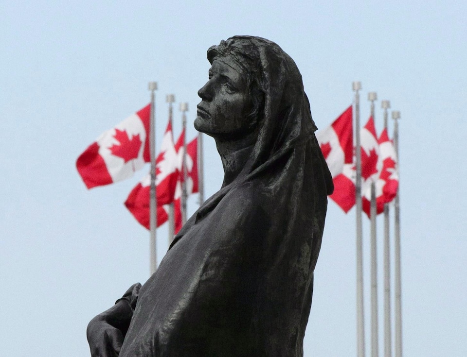 Visage de la statue Veritas entourée de drapeaux du Canada en mai 2018 à Ottawa.