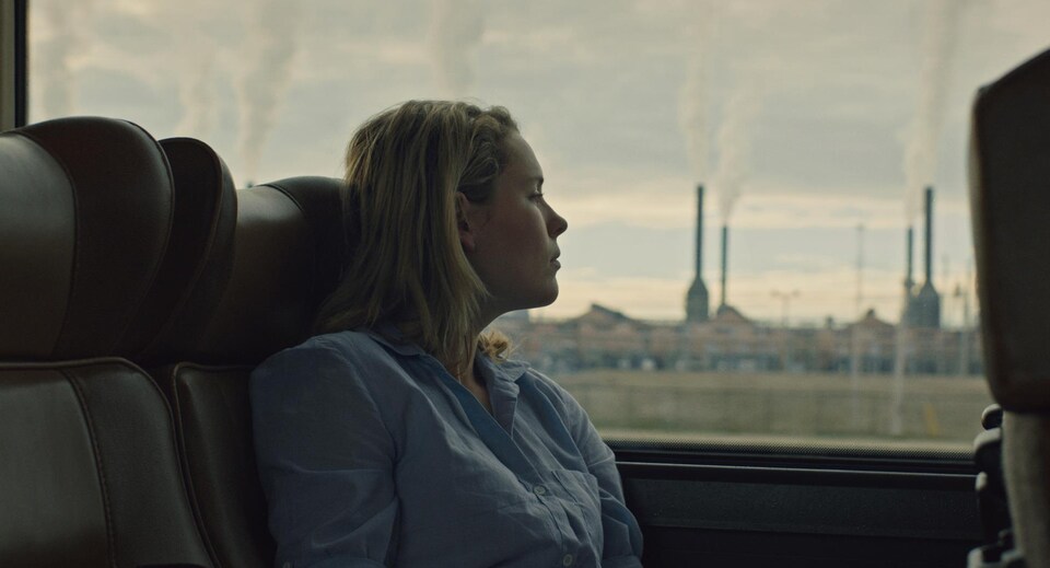Une actrice sur un banc d'autobus, elle regarde par la fenêtre.