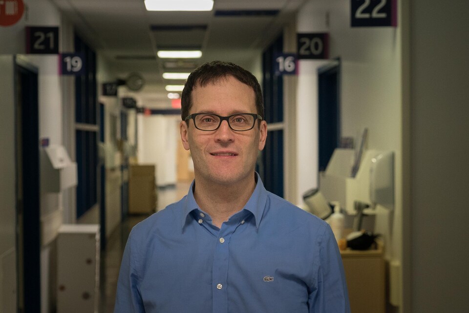 Le docteur Patrick Hamel, portant une chemise bleue, dans un corridor de l'hôpital Sainte-Justine, à Montréal