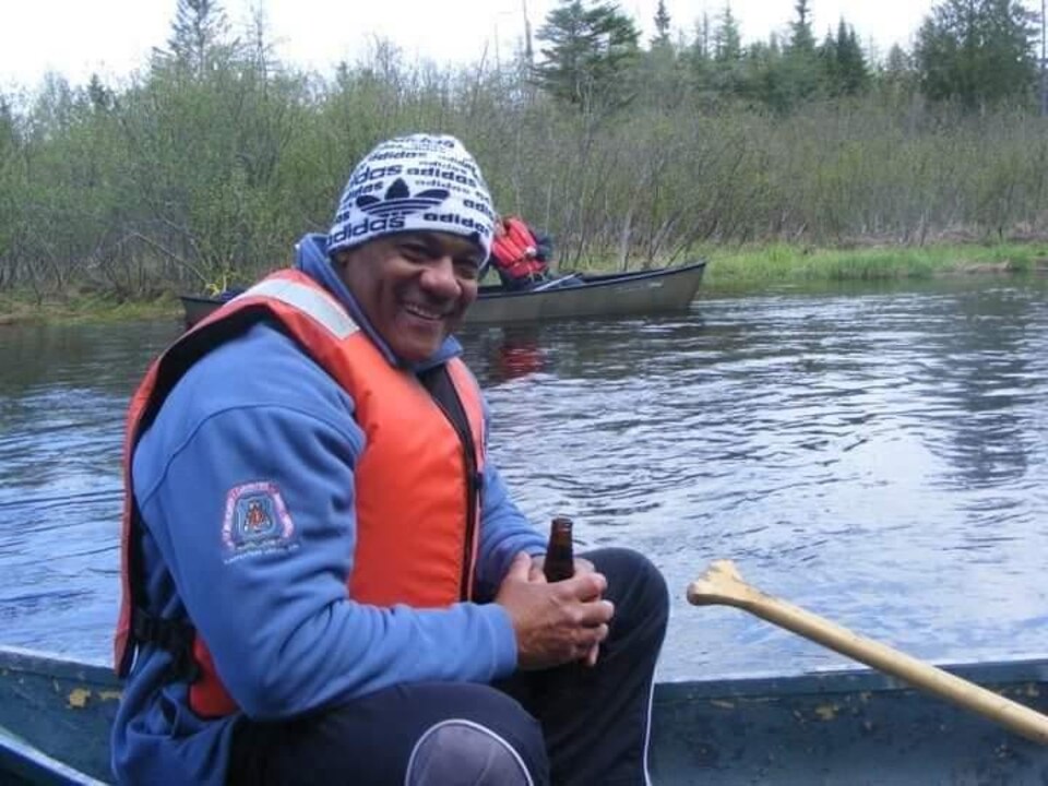 Un homme souriant assis dans un canot.
