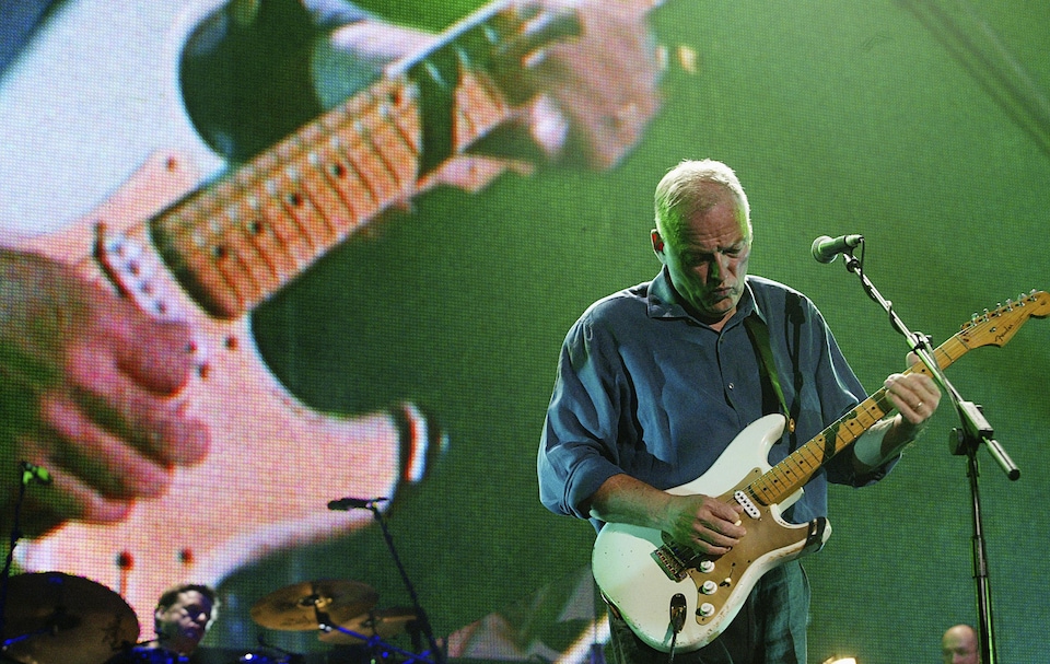 Gilmour, sur scène, s'exécute sur la guitare blanche plutôt usée.