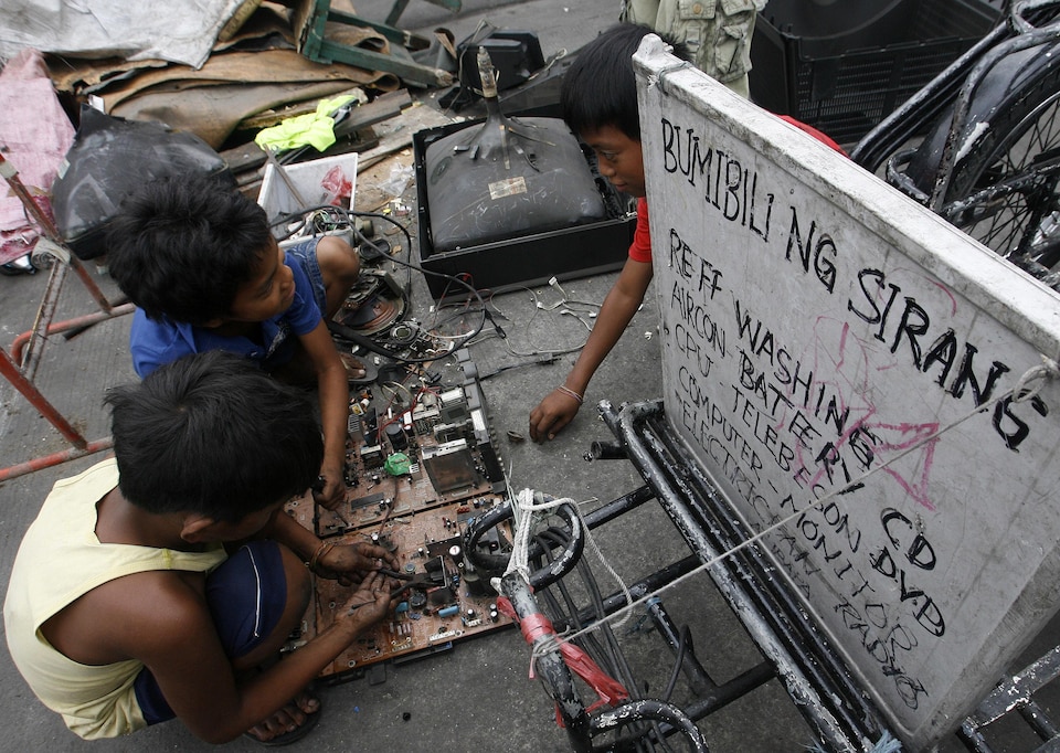 À Manille, des enfants extraient à la main les métaux précieux d’anciens ordinateurs et téléviseurs. 