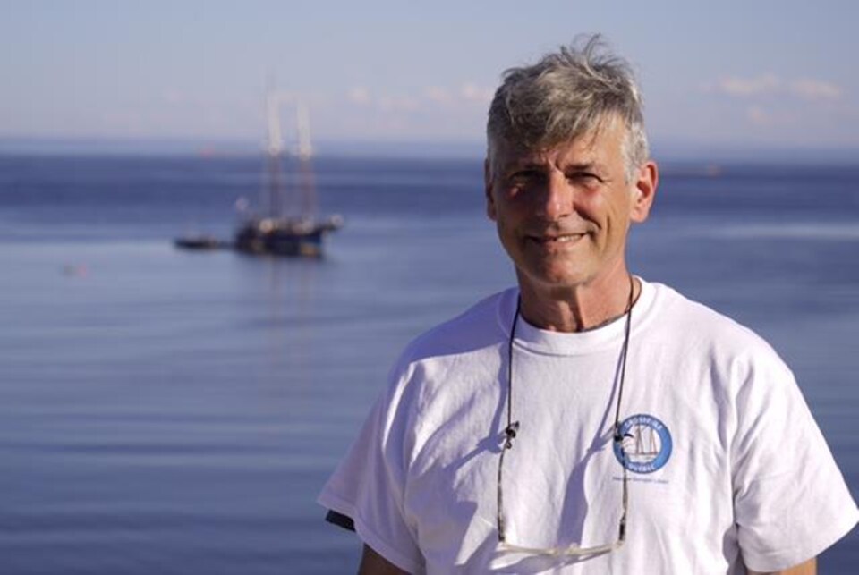 Didier Épars devant son bateau, la goélette Grosse-Île